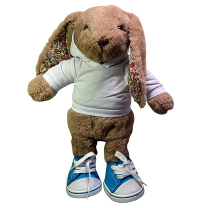 knuffel konijn van Make a Bear heeft hier blauwe sneakers aan. deze schoenen zijn speciaal voor knuffel. Ze zijn blauw en wit van kleur. 